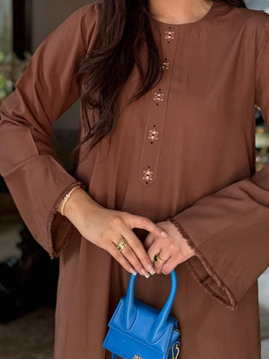 A solid coffee-brown traditional ladies kurta with fringe edges on the sleeves and kurta patti in the center.