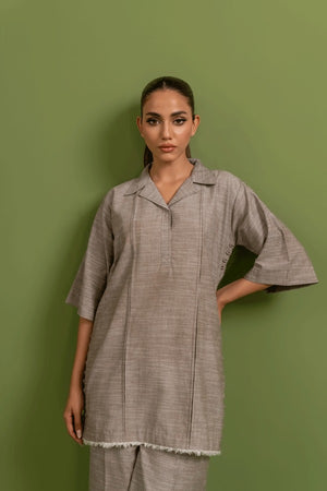 A model wearing a earthy beige two piece co-ord set with three-quarter sleeves and straight pants.