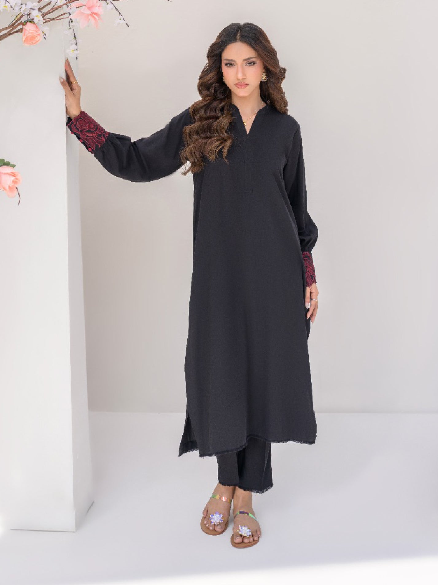 Woman wearing a black outfit with maroon sleeves  embroidery.