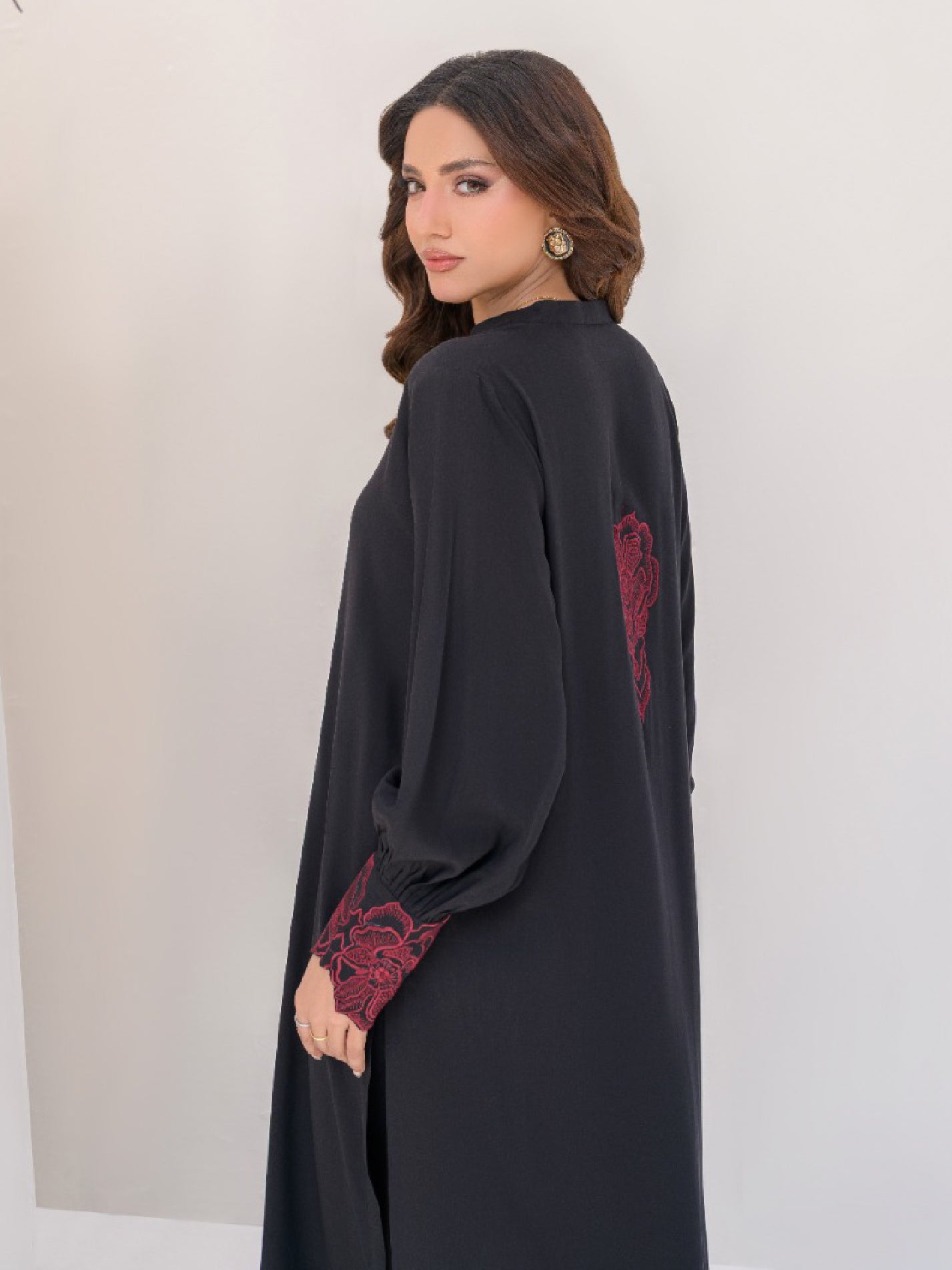 Women black summer outfit ,red motif on back of shirt and embroidery on sleeves cuff in Pakistan.