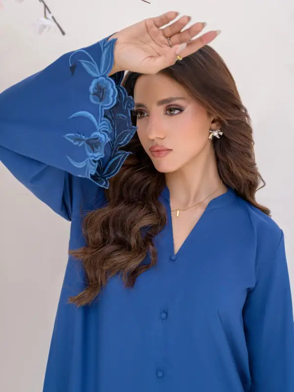 Close-up of blue floral cutwork embroidery on boski linen flared sleeve cuff